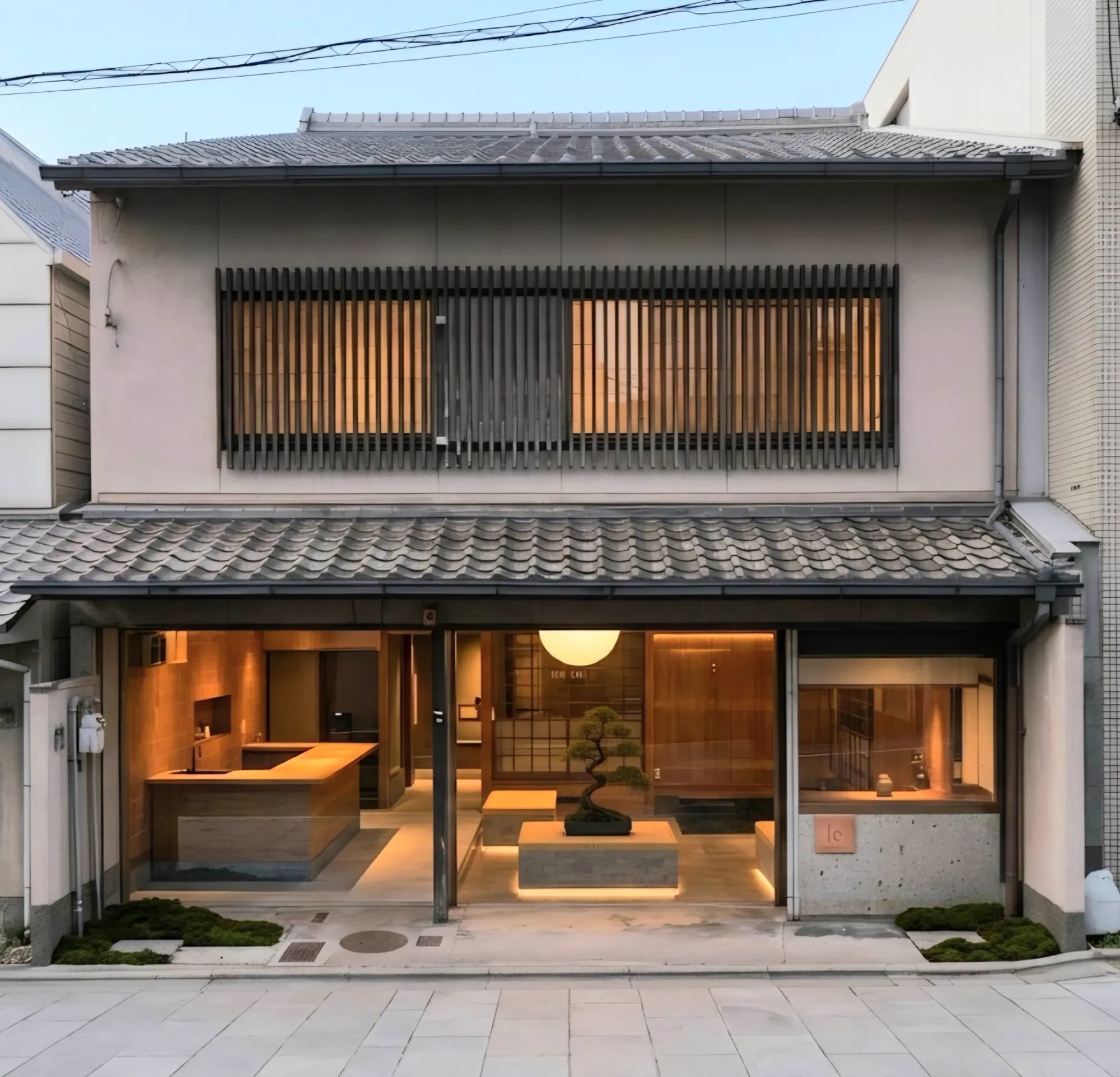 The front of the house on the street: a timber lattice above, the ground floor open and lit.