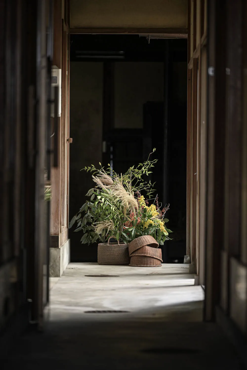 A dark passage ending in dried grasses and baskets.