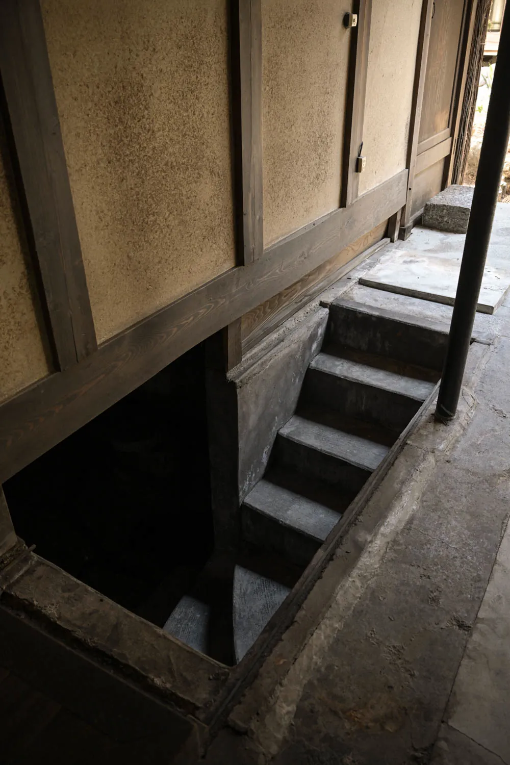 Old steps drop through an opening in the floor into darkness.